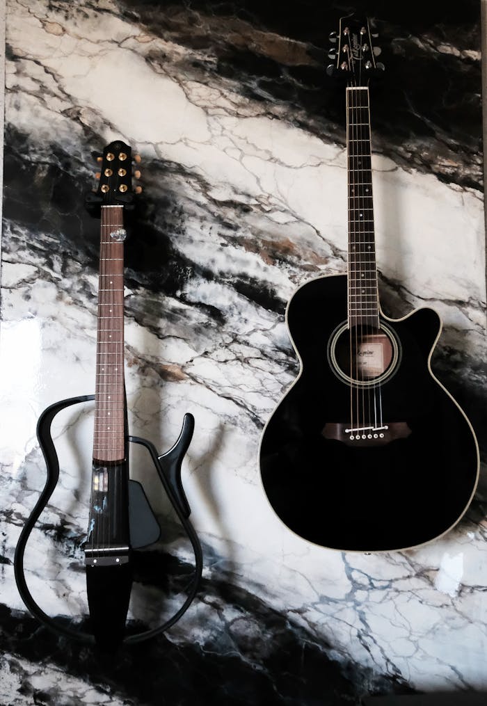 gallery-1 Close-up of two elegant guitars mounted on a marble surface.