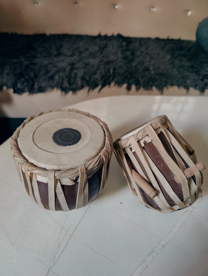 High-detail image of two cylindrical Indian tabla drums on an indoor surface.