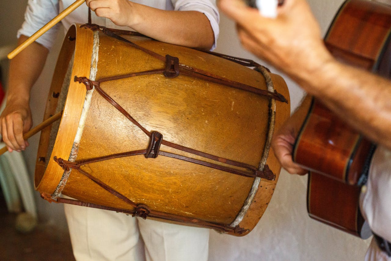 services-04 Musicians performing with a bombo drum and guitar, capturing the essence of traditional music.